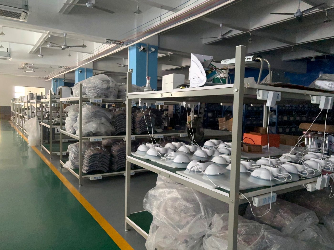 SaintQueen™ production workshop — finished beauty devices on assembly racks