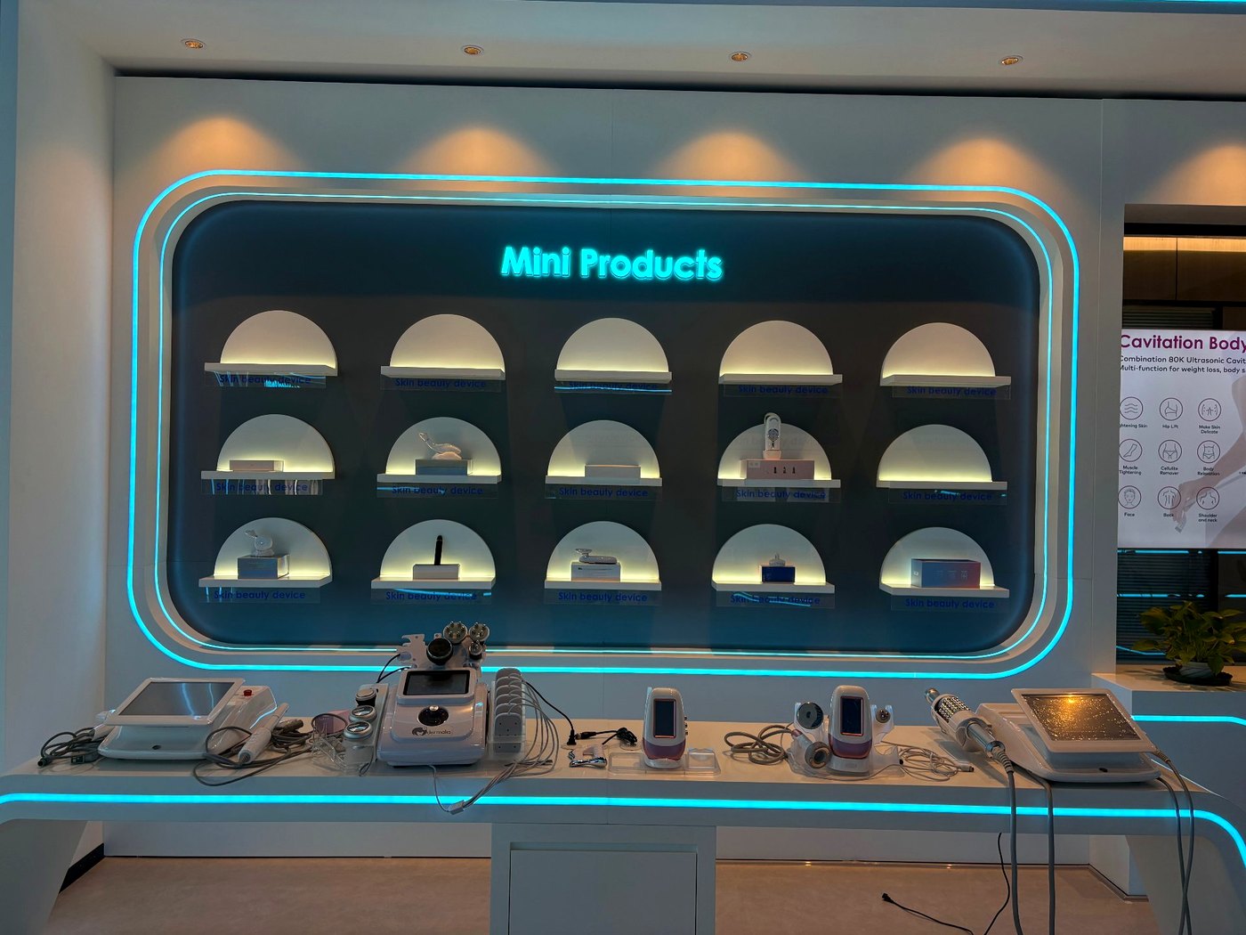 SaintQueen™ showroom — Mini Products neon wall showcasing compact beauty devices