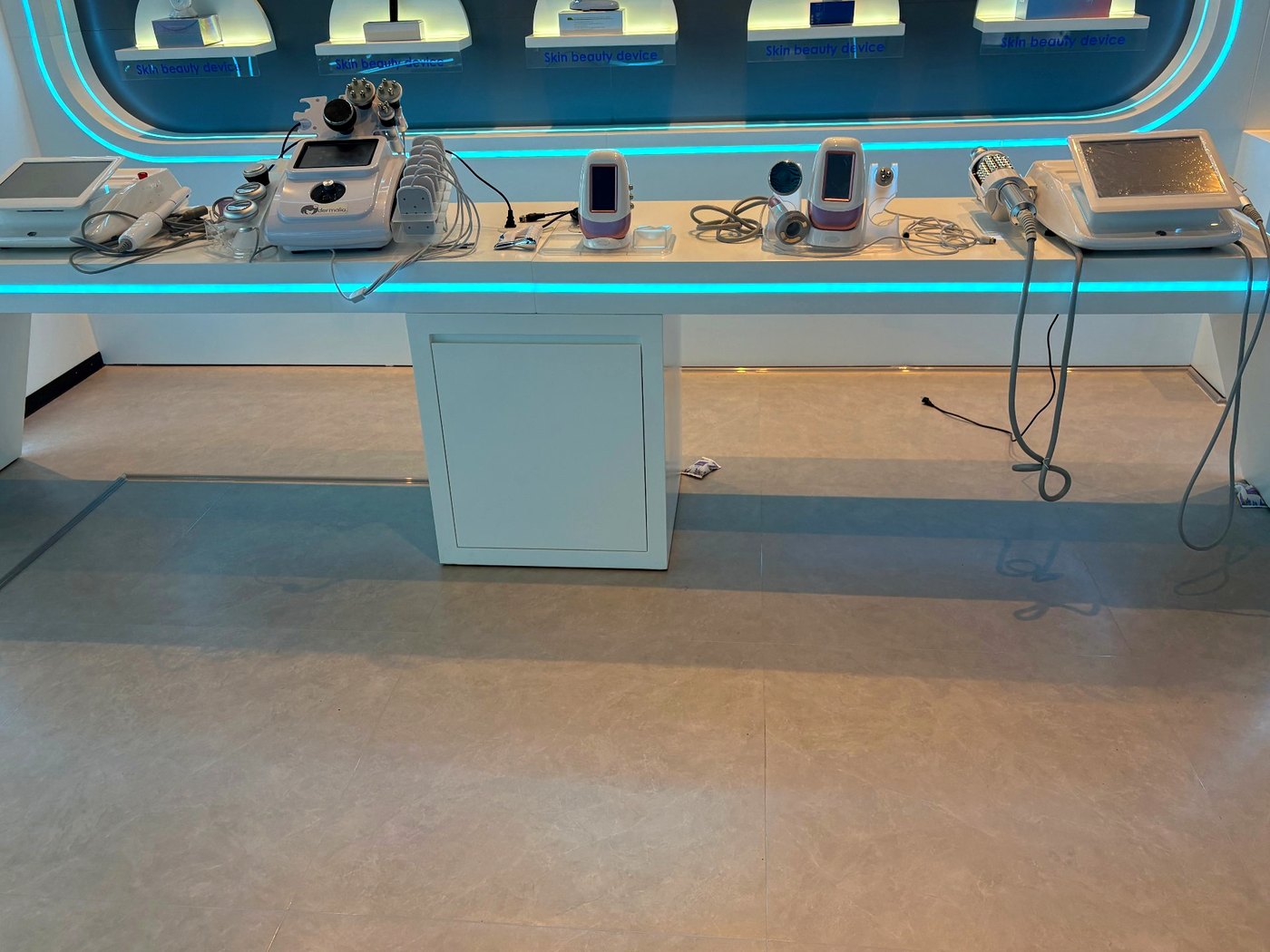 SaintQueen™ showroom — professional-grade display counter with mini aesthetic devices and LED accent lighting